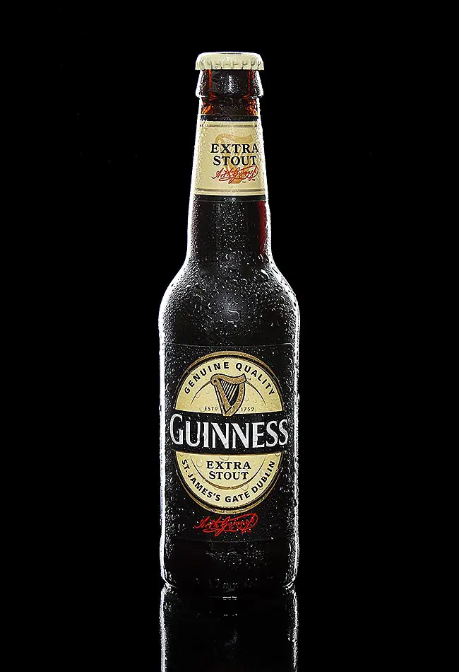 Zdjęcie produktowe butelki piwa Guinness na czarnym tle