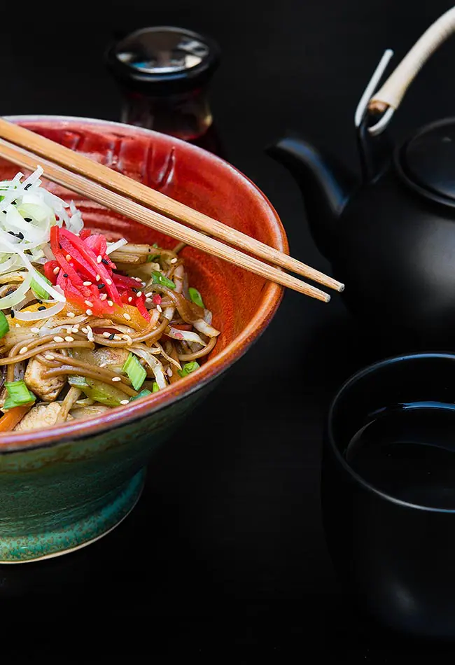 Zdjęcie kulinarne — makaron ramen w czerwonej misce z pałeczkami