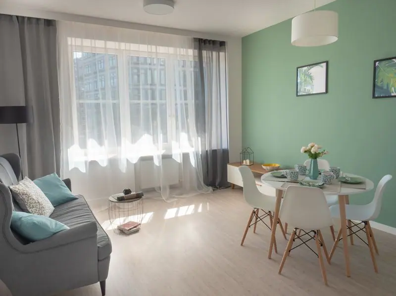 Zdjęcie wnętrza mieszkania — jasny salon z kanapą i jadalnią
