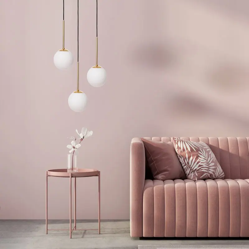 Zdjęcie lifestyle'owe lamp wiszących nad różową sofą