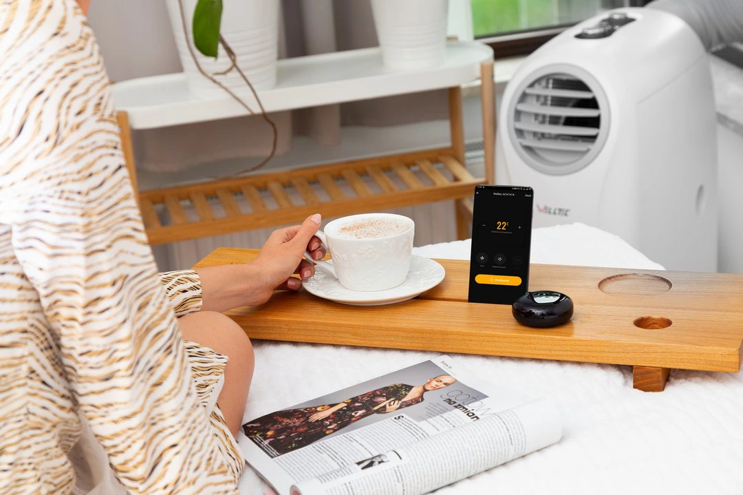 Klimatyzator przenośny obok stolika z kawą i gazetą — zdjęcie lifestyle